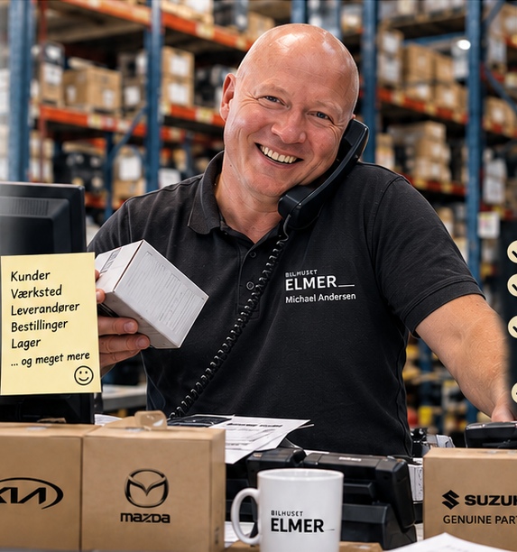 Reservedelschef Michael Andersen med telefon og reservedele på lageret hos Bilhuset Elmer